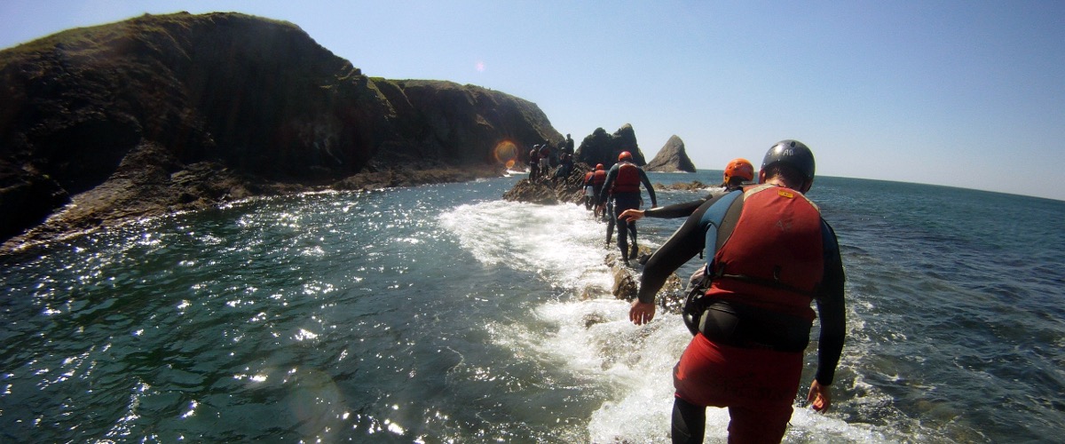 Coasteering across the reef at Ceibwr Bay